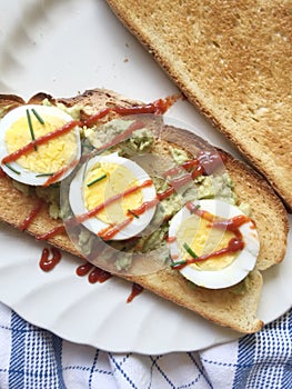 Avocado and egg sandwich with Sriracha