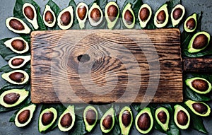 Avocado. Frame made from avocado palta and avocado tree leaves around wooden board. Guacamole ingredients. Healthy fat, omega 3. H photo