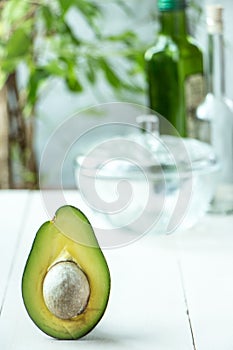 Avocado fruit cutted in half at rustic white wooden background