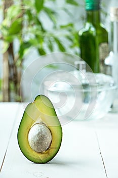 Avocado fruit cutted in half at rustic white wooden background