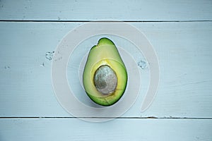 Avocado fruit cutted in half at rustic white wooden background, raw and vegan food photography