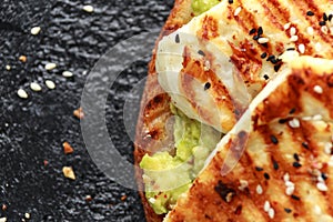 Avocado and grilled haloumi cheese toast with nigella and sesame seeds. healthy breakfast