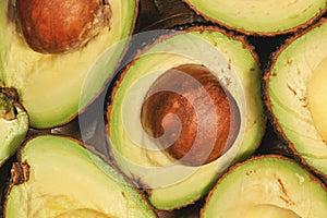 Avocado halves, with brown seed inside, closeup detail view from above