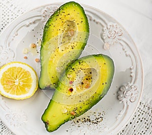 Avocado halves with butter salt and pepper