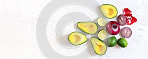 Avocado halves, limes and onions - basic guacamole ingredients on white working board, flat lay photo, wide banner with