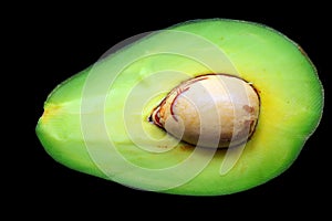 avocado with a large seed in the middle on black background