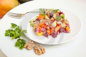 Avocado, mango, beetroot and walnut salad on white background