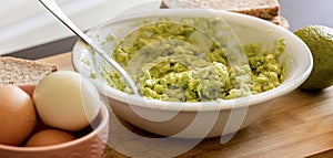 Avocado Mashing in a Bowl on Wooden Board