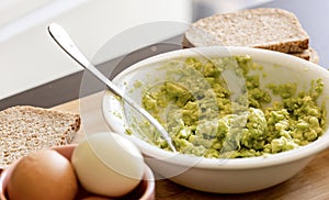 Avocado Mashing in a Bowl on Wooden Board