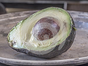 Avocado, Persea americana in half on table