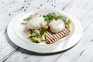 Avocado and poached egg on toasted bread with basil. Food recipe background. Close up