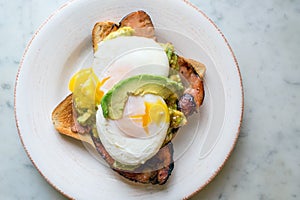 Avocado with pouched eggs and bacon on toast