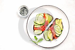 Avocado salmon toasts  served on a dish, top down view