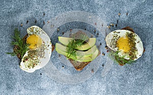 Avocado, sandwiches on whole grain bread with tri-colored tomatoes on rustic baking tray