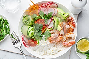 Avocado, shrimps, cucumber, tomato, radish, carrot and rice salad bowl. Healthy food