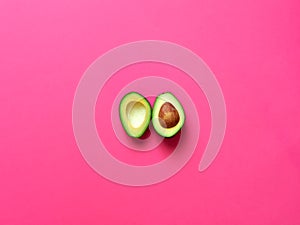 Avocado sliced with seed in fuscia