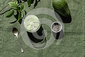 Avocado smoothies with chia seeds. Green color next to the ingredients, top view. Superfood, healthy eating