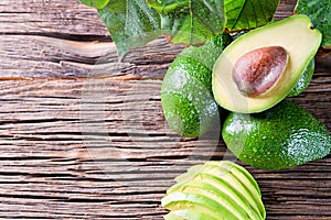 Avocado split in half on old wooden table with free space for your text.