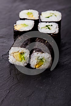 Avocado sushi roll on black slate board