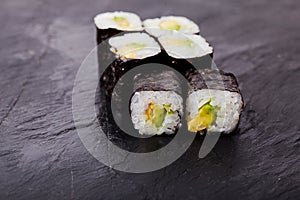 Avocado sushi roll on black slate board