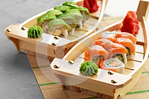 Avocado sushi roll and roll with salmon served on wooden plates
