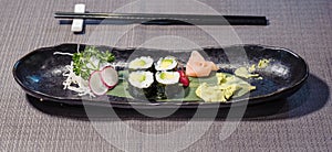 avocado sushi served on a bamboo leaf, with radishes and daikons julienne, ginger gari and horseradish wasabi, typical japanese f