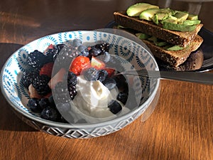 Avocado toast and bowl of berries and yogart breakfast photo