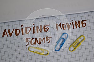 Avoiding Moving Scams write on a book isolated wooden table