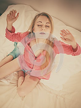 Awaken woman stretching body after sleeping