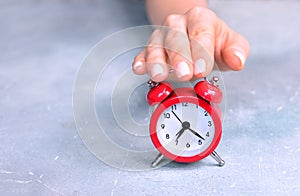 Awakening concept background with woman hand reaching to turn off alarm clock
