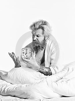 Awakening. Stressed man alarm clock. Sleepy guy and alarm clock in bed. Bearded man with alarm clock. Sleep complex