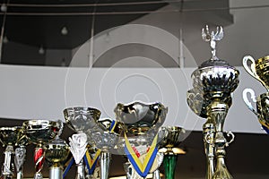 Award ribbons on gold and silver sports cups for prize-winning places