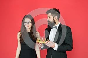 Awarding ceremony. Prom couple. Couple in love red background. Couple of sensual woman and bearded man with crown