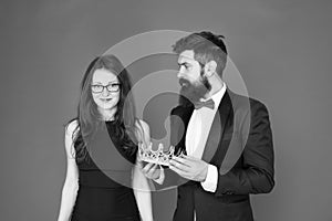 Awarding ceremony. Prom couple. Couple in love red background. Couple of sensual woman and bearded man with crown