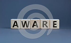 Aware symbol. Wooden cubes with the word `aware`. Beautiful grey background. Business and aware concept. Copy space