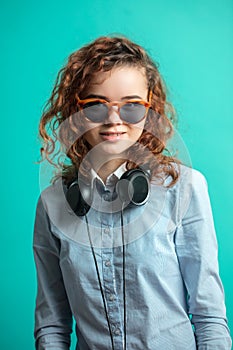 Awasome street girl with headphones on neck isolated on the blue background