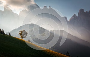 Awesome Alpine highlands during sunrise. foggy morning in Dolomites mountains - mountain range silhouttes. Amazing Nature