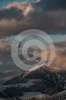 awesome beautiful view of sky and grey clouds and winter mountain landscape with snow covered evergreen trees