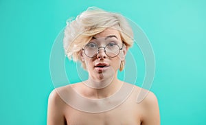 Awesome blond girl in glasses looks surprised