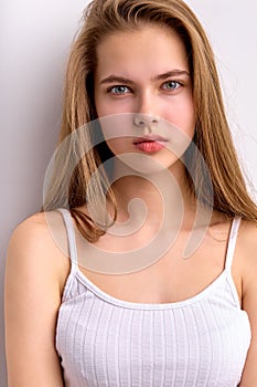 Awesome caucasian female with natural long brown hair posing at camera, in white undershirt