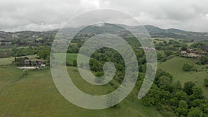 Awesome countryside aerial view with green valley and trees, hills and meadows