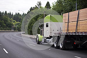 Awesome customized big rig white and green semi truck with flat