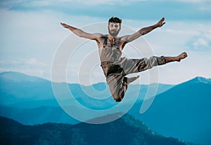 Awesome dancer is jumping very high on a mountain hill