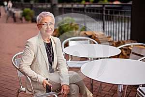 Awesome female is waiting her order at the cafe