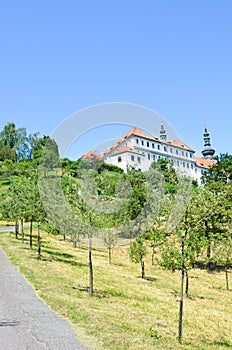 Awesome green park on Petrin Hill in the old town of beautiful Prague, Czech Republic. Old house with tower in background. Sunny