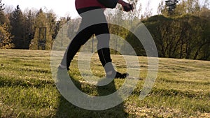 Awesome shot of a middle aged lady walking on grass on a sunny day.