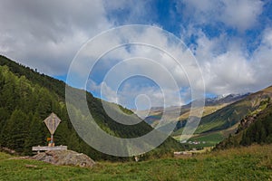 Awesome summer panorama of South Tyrolean valley with wooden capital and rainbow