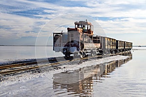 Awesome train rides on rail in the water with white salt on the background of beautiful blue sky