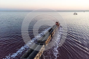 Awesome train rides on rail in the water with white salt on the background of beautiful blue sky. aerial view, view from