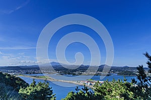 Awesome view of seaside small city within seongsun ilchubong jeju island south korea with yellowish grass foreground and slightly